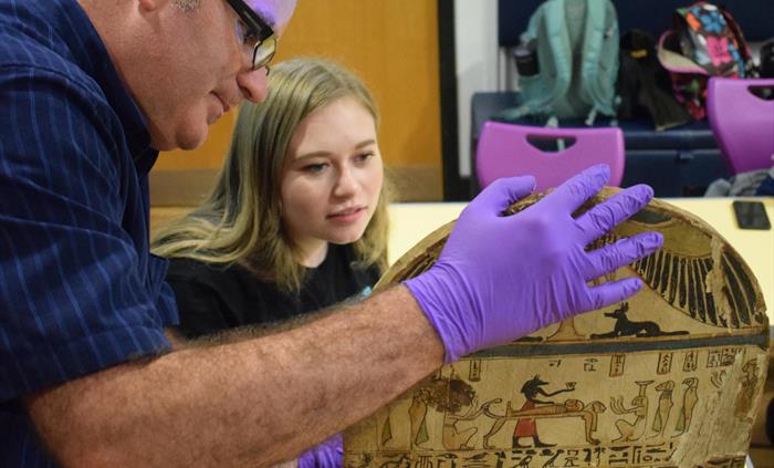 Curator and Student Volunteer studying Graeco-Roman era wooden funerary stela of Pashrinyemhotep.